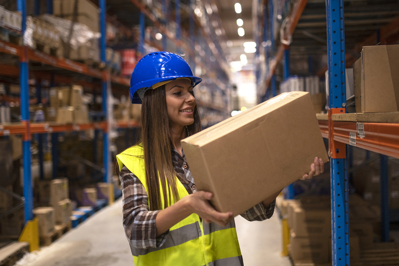 imagen de una mujer trabajando en almacén colocando una caja.
