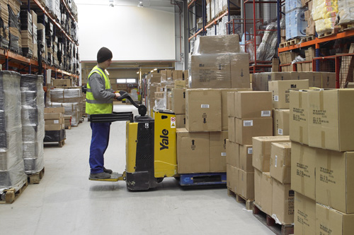 Operario trabajando, colocando mercancía en un almacén.