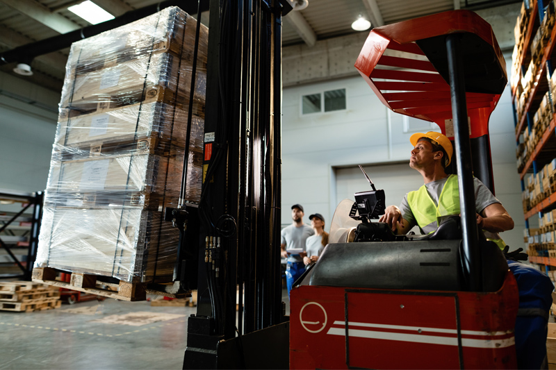 imagen operario levantando carga con apilador.